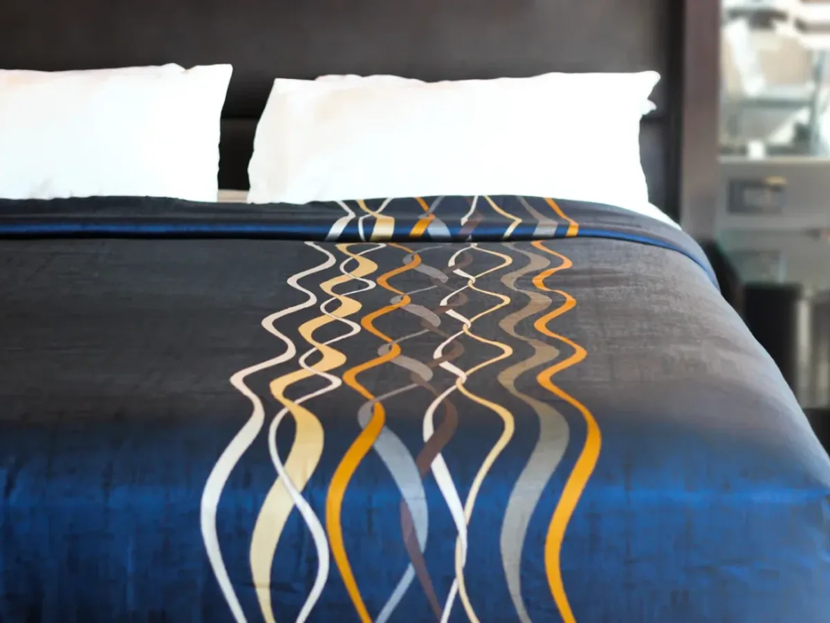 Hotel guest room bed dressed in fresh CATELS linens